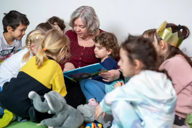 Erzieherin mit Kindern beim Vorlesen
